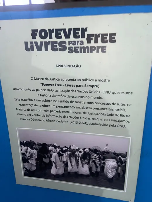 Painel de apresentação da mostra Forever Free, Livres para Sempre, com foto de um grupo de mulheres de branco