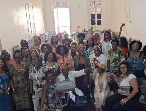 Auditório cheio de mulheres com roupas e turbantes africanos